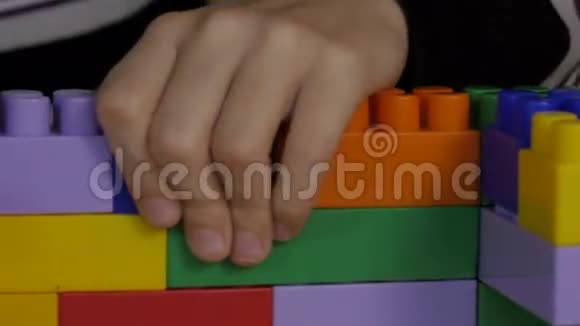 坐在桌子旁的彩色积木里玩耍的男孩视频的预览图