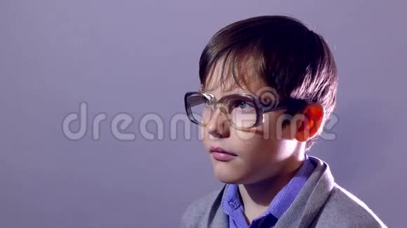 男孩书呆子少年肖像男孩眼镜紫色背景教育视频的预览图