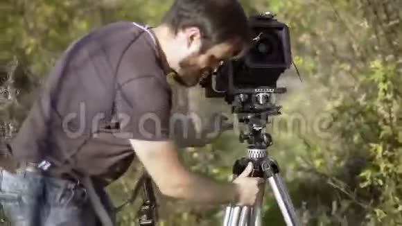 在绿树丛中放置复古相机视频的预览图
