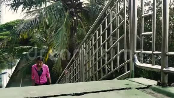 早上在人行道上奔跑的年轻亚洲女人年轻的运动亚洲女人在城市楼梯上跑楼上视频的预览图