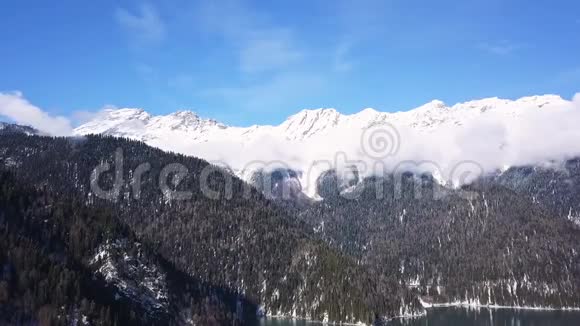 全景观美丽的白色冬季仙境风景与雪山峰会剪辑寒冷的晴天蓝色视频的预览图
