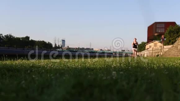 慢跑女孩跑在绿草上视频的预览图