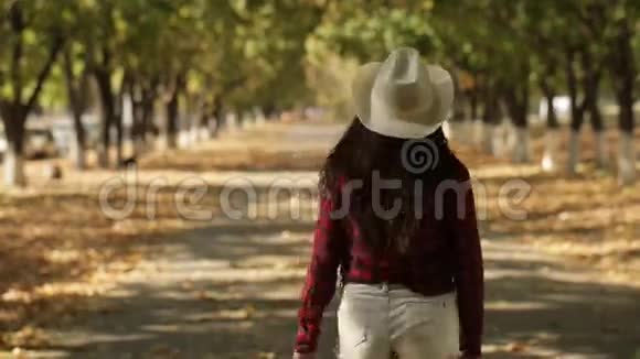 戴帽子的女孩在一条秋天的小巷里走了视频的预览图