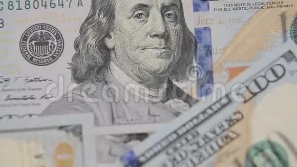 近距离拍摄分散的美国纸币现金背景本杰明富兰克林100美元双人肖像视频的预览图