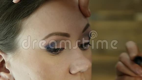 专业化妆师的特写用大刷子给模特的眼睛染色时尚界化妆品视频的预览图