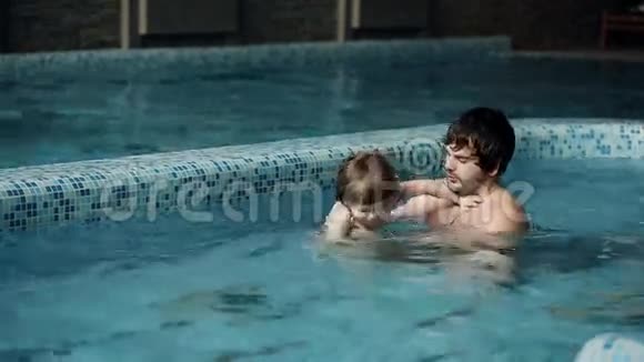 游泳课父亲在游泳池里教儿子游泳视频的预览图