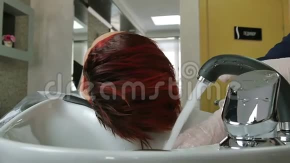 戴手套的理发师洗头发特写视频的预览图