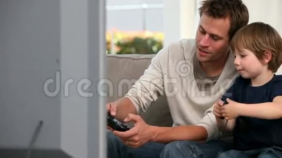 小男孩和他父亲玩电子游戏视频的预览图