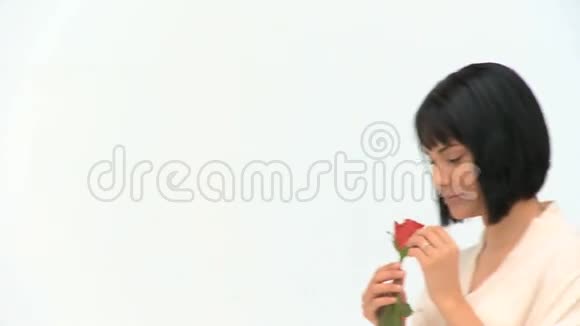 一个可爱的中国女人拿着一朵花视频的预览图