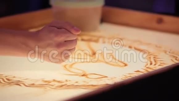 沙子动画女孩用手拿沙子画画视频的预览图