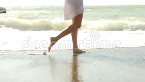 慢动作特写幼女长腿在沙滩上行走将海水喷洒到镜头中4k视频的预览图