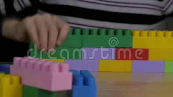 坐在桌子旁的彩色积木里玩耍的男孩视频的预览图