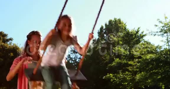小女孩在公园里被妈妈推着荡秋千视频的预览图