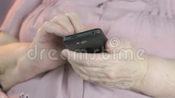 一位老妇人在黑色智能手机上键入文本视频的预览图
