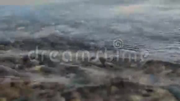沙滩上的石与弹珠纯净的水波视频的预览图