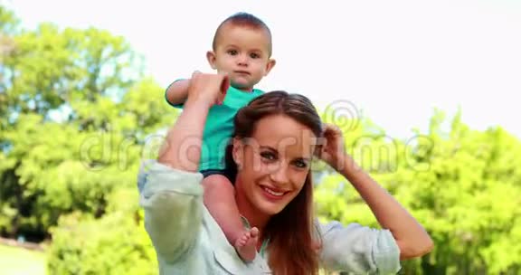 快乐的妈妈在公园里抱着可爱的小儿子视频的预览图