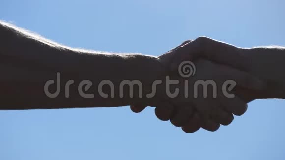 在蓝天背景下友好地握手两个无法辨认的肌肉白人男子户外男性手臂晃动二视频的预览图