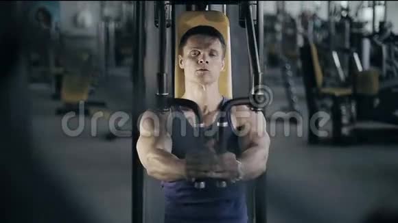 肌肉健美运动员在健身房锻炼乳房肌肉正面拍摄视频的预览图