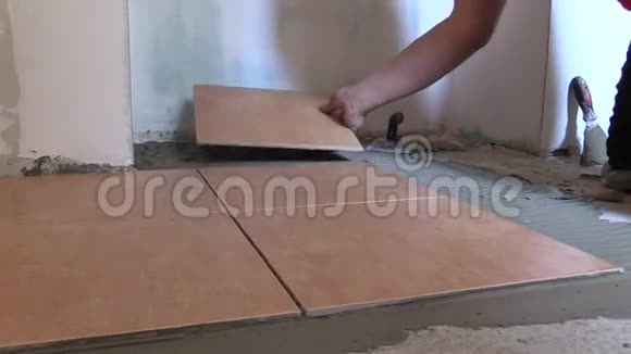 用手把瓷砖放在家门口的水泥胶上视频的预览图