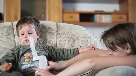 妈妈和生病的小男孩用雾化器吸入药品股票录像视频的预览图