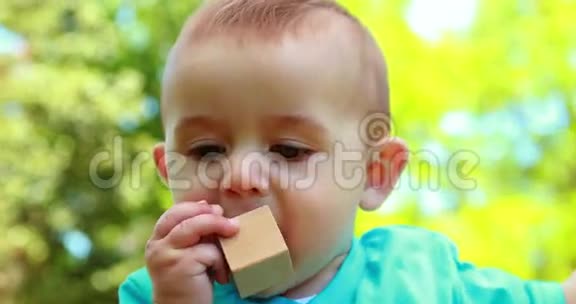 可爱的小男孩咀嚼积木视频的预览图