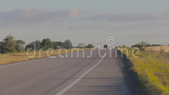 这辆车行驶在Pshenichnyh田野之间的乡村公路上日落时分的机器在麦田的背景下视频的预览图