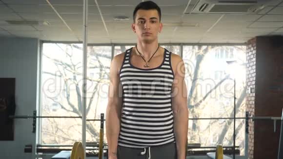 强壮的男人在肱二头肌上用杠铃做运动视频的预览图