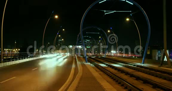 高峰时段有车和火车的夜间交通时间间隔倾斜4k视频的预览图