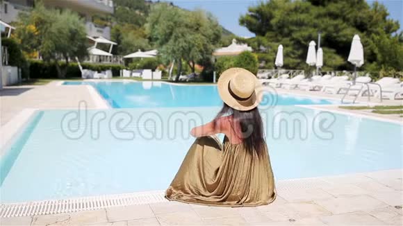在豪华酒店度假胜地的泳池边放松的女士享受完美的海滩度假视频的预览图