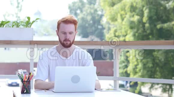 在笔记本电脑上工作人坐在办公室阳台上室外视频的预览图