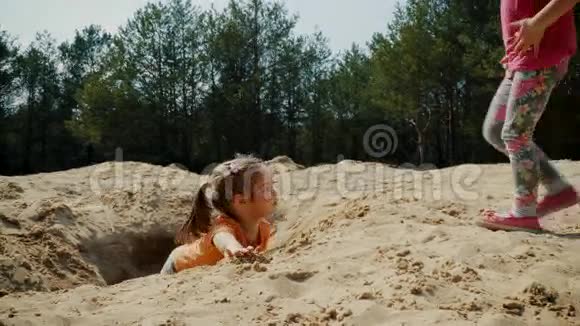 可爱的女孩在树林里的沙滩上玩耍视频的预览图