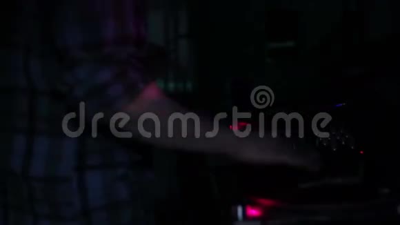 DJ在夜总会循环视频中在迪斯科舞厅刮擦唱片并在甲板上混音视频的预览图