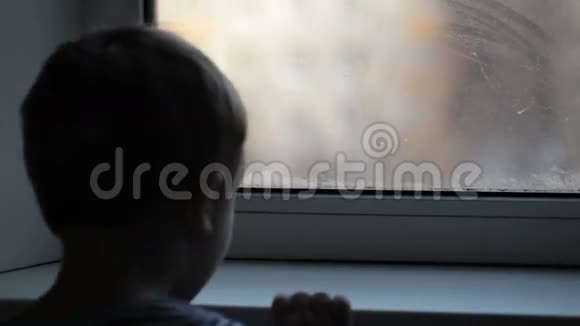 小男孩透过薄雾的窗户看着视频的预览图