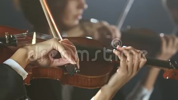 音乐家拉小提琴的特写黑烟背景视频的预览图