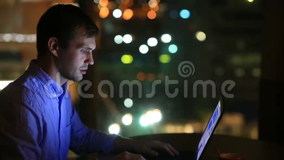 漂亮的商人晚上在行政办公室加班从一个大的背景中可以看到城市的灯光视频的预览图