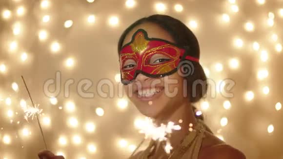 美丽的年轻女子戴着狂欢节面具手里拿着孟加拉灯视频的预览图