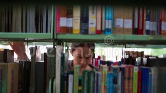 女学生走在书架之间寻找书籍视频的预览图