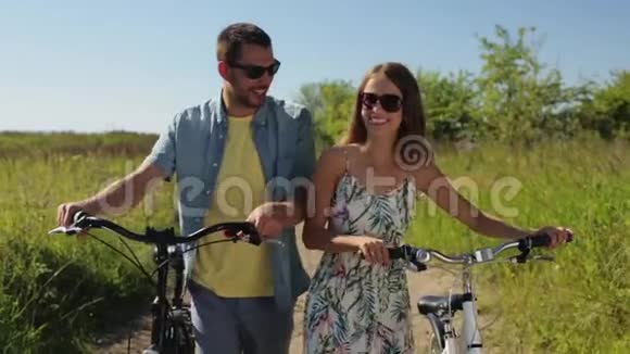 快乐的年轻夫妇骑着自行车在夏天散步视频的预览图