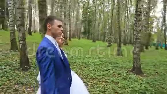 新婚夫妇新婚夫妇在夏季公园散步视频的预览图