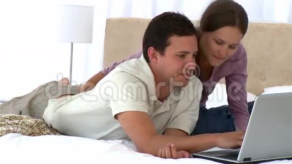一对情侣在笔记本电脑上看视频视频的预览图