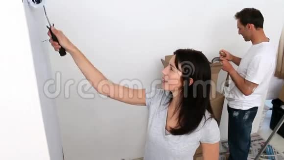 一对夫妇用白色画一堵大墙视频的预览图