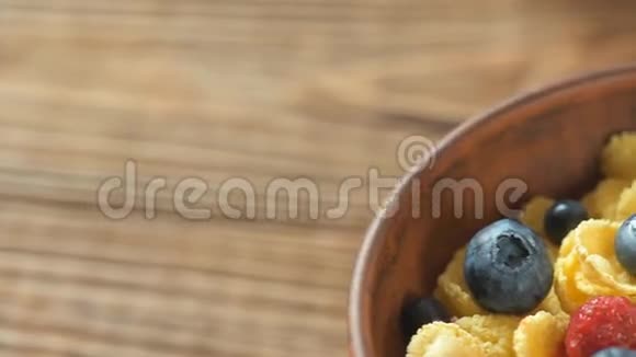 在木制背景下的玉米片和新鲜浆果碗视频的预览图