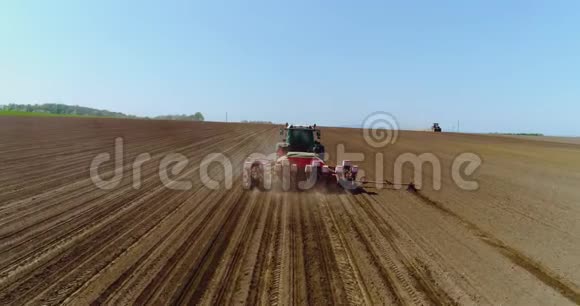 拖拉机在收获田耕田上的高空作业视频的预览图