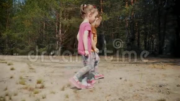 可爱的女孩在树林里的沙滩上玩耍视频的预览图