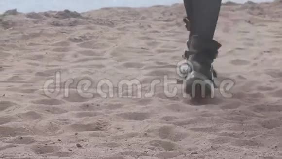 穿着黑鞋在沙滩上散步的女孩的修长的腿视频的预览图