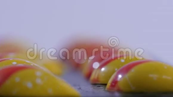 在白色背景上关闭两个焦糖糖果咸焦糖片一排白色背景的焦糖糖果视频的预览图