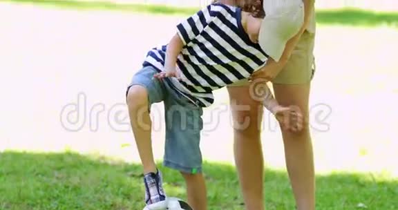 妈妈和她的小儿子在踢足球视频的预览图