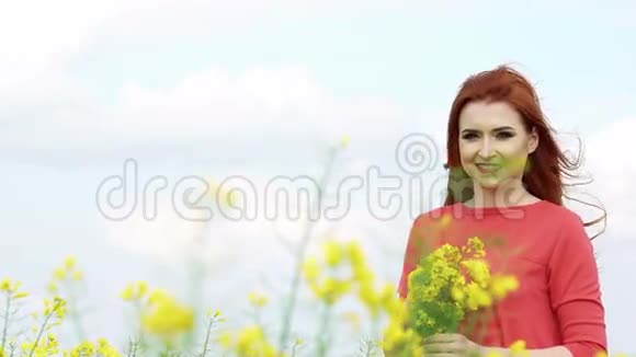 金发姑娘带着鲜花在田野里微笑慢慢地视频的预览图