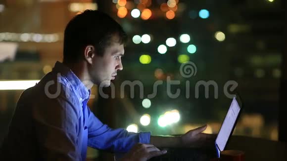 漂亮的商人晚上在行政办公室加班从一个大的背景中可以看到城市的灯光视频的预览图