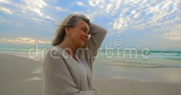 站在海滩上的活跃的高加索族妇女的侧面景色视频的预览图